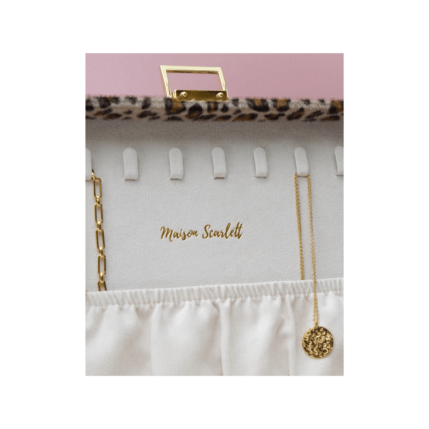 Logo doré Maison Scarlett embossé dans la boîte à bijoux léopard
