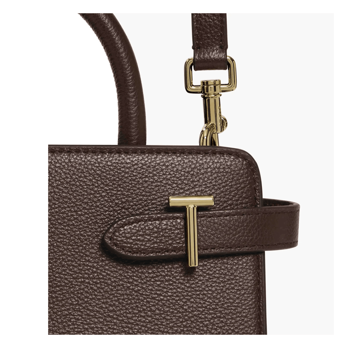 Gros plan du cuir grainé marron foncé du sac Émilie Le Tanneur avec fermoir décoratif T et mousqueton doré