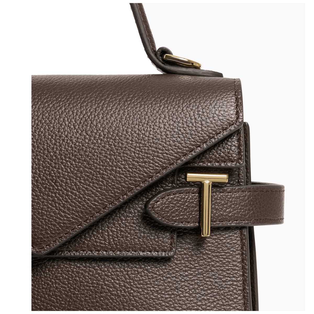 Gros plan du sac Le Tanneur Émilie marron foncé, texture du cuir de vachette pleine fleur grainé et détail métallique doré en T