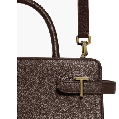 Gros plan du cuir grainé marron foncé du sac Émilie moyen modèle Le Tanneur, détail du T doré et mousqueton de bandoulière