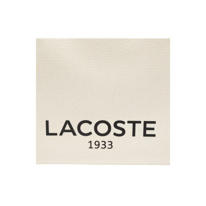Détail logo Lacoste sur toile coton natural tan du sac Héritage Canvas