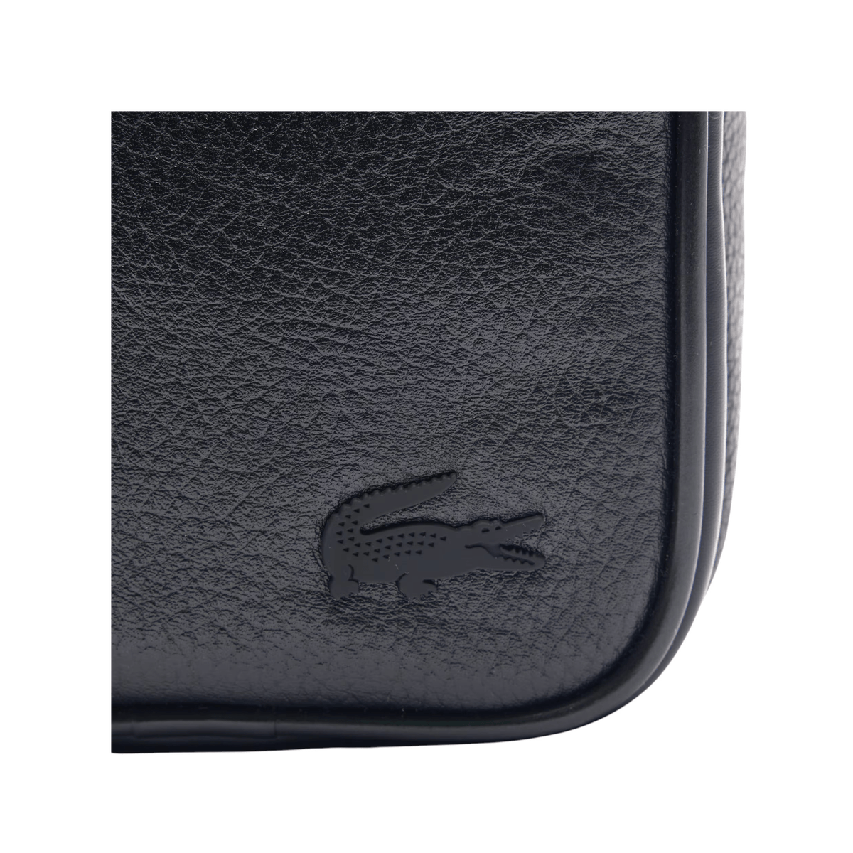 Gros plan sur le crocodile Lacoste ton sur ton et la texture grainée de la sacoche homme noire NH4563GY000