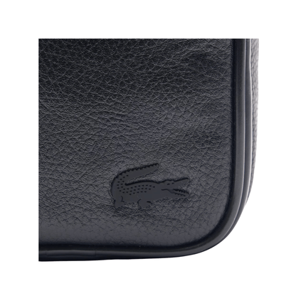 Gros plan sur le crocodile Lacoste ton sur ton et la texture grainée de la sacoche homme noire NH4563GY000
