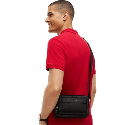 Homme portant la sacoche bandoulière noire Tommy Hilfiger AM0AM14696 avec bandoulière ajustable