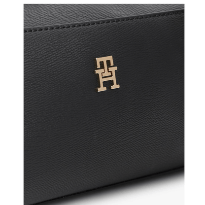 Gros plan monogramme TH doré et matière texturée du sac Tommy Hilfiger noir